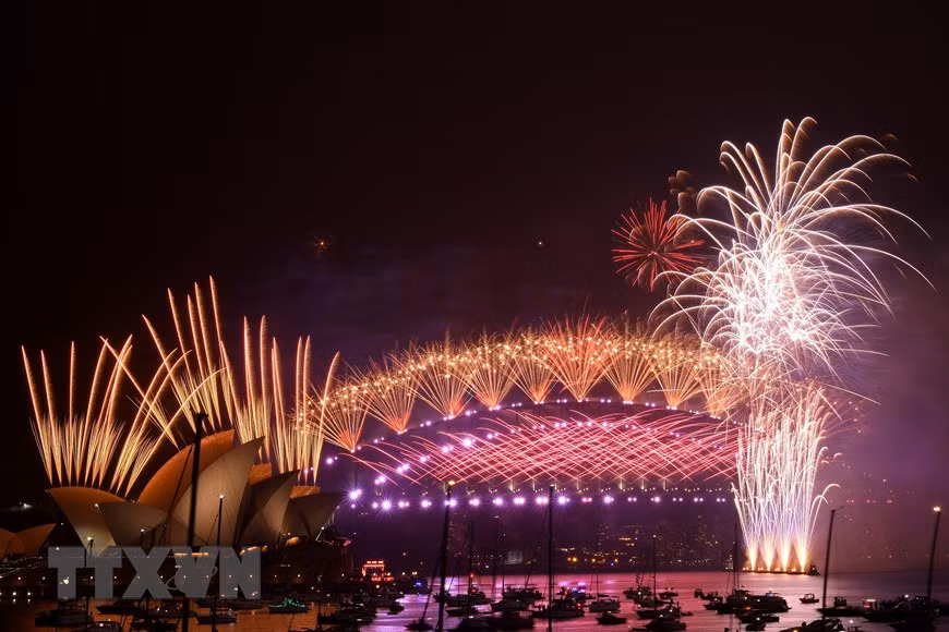 Pháo hoa mừng Năm mới rực rỡ trên cầu cảng Sydney. (Ảnh: AFP/TTXVN)