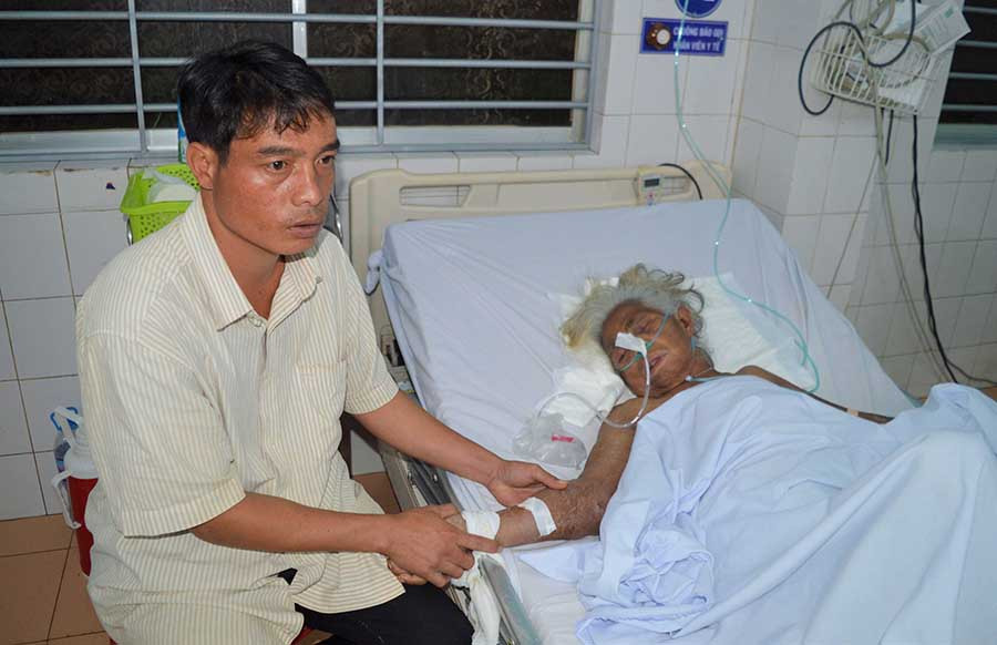  Anh Siu Tuất chăm sóc mẹ đang điều trị tại Bệnh viện Đa khoa tỉnh. Ảnh: H.T