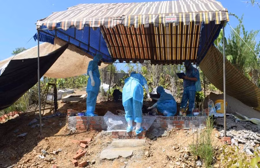 Các Bác sĩ pháp y đang tiến hành khám nghiệm, giám định tử thi tại Nghĩa địa thôn 9, xã Nam Dong, huyện Cư Jút, tỉnh Đăk Nông để tìm ra nguyên nhân anh Lượng chết. Ảnh: Đình Ngự