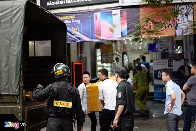 Cảnh sát tạm giữ nhiều thùng hàng khi khám xét các cửa hàng của Nhật Cường Mobile. Ảnh: Hải Nam.