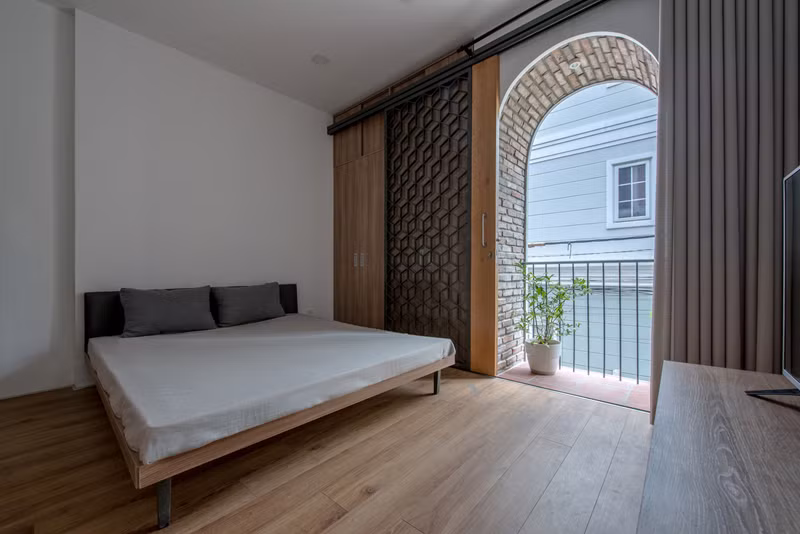  Phòng ngủ dành cho khách có ban công để ngắm khoảng sân vườn bên ngoài.