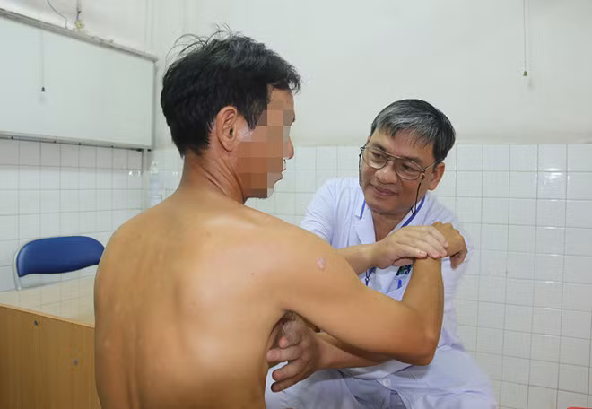 Bác sĩ Phạm Hùng Cường, Trưởng khoa Ngoại 2, Bệnh viện Ung bướu TP.HCM, thăm khám cho bệnh nhân nam bị ung thư vú