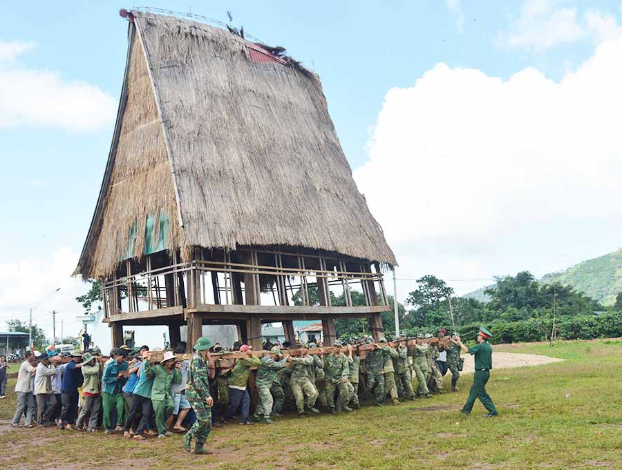 Cán bộ, chiến sĩ lực lượng vũ trang tỉnh tham gia di dời nhà rông ở xã Chư Đăng Ya, huyện Chư Pah. Ảnh: P.D