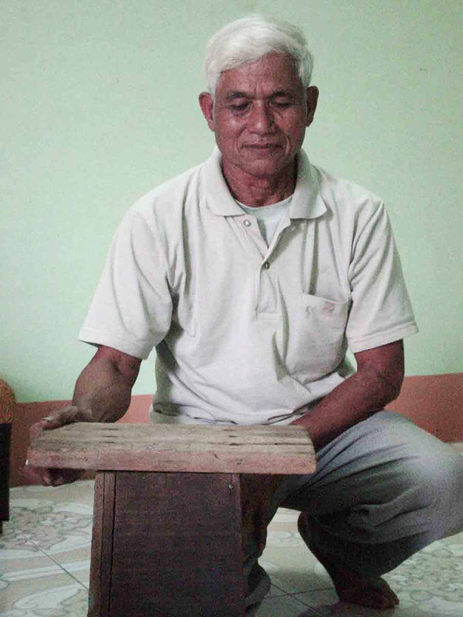 Ông Nay Val với chiếc ghế do Jacques Dournes đóng, hiện được ông giữ làm kỷ niệm. Ảnh: N.T