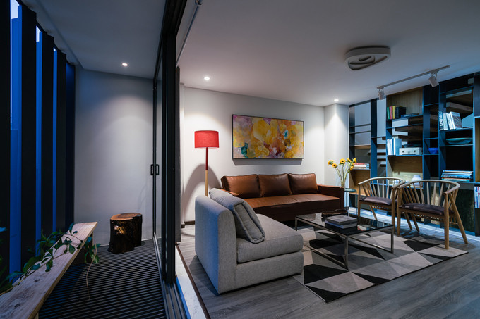 Buổi tối, khi cánh cửa kính được mở toang đón gió, không gian phòng khách như mở rộng hơn nhờ được nối liền với ban công bên ngoài.