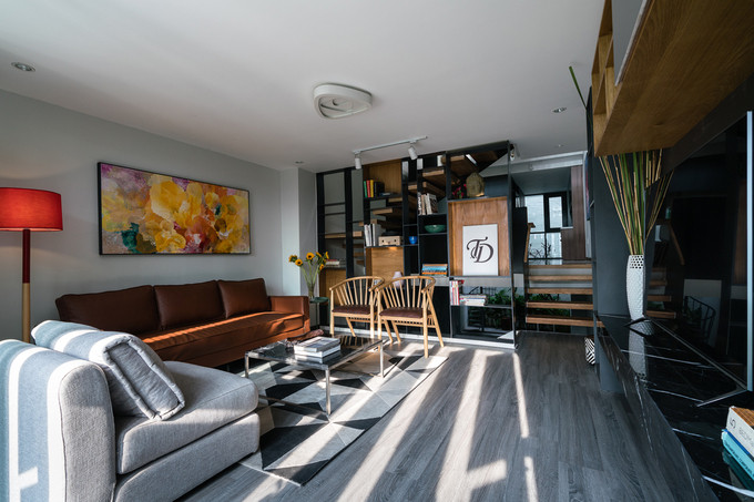 Phòng khách nằm ở phía trước tầng hai. Ban ngày, những tia nắng hắt qua hệ lam từ phía mặt tiền khiến ánh sáng trong phòng trở nên lung linh.