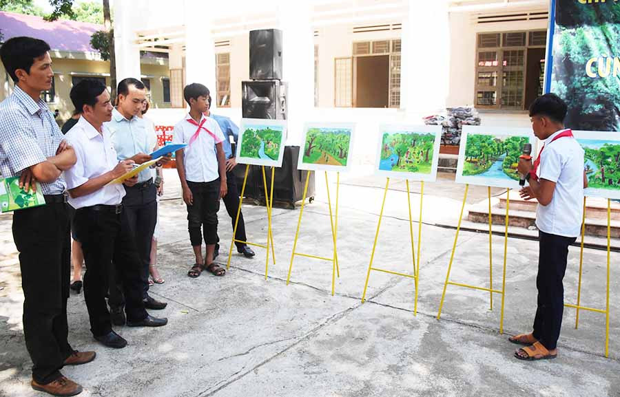 Em Quinh (lớp 9B, Trường THCS Hà Tây) thuyết trình với Ban giám khảo về ý nghĩa bức tranh của mình. Ảnh: M.N