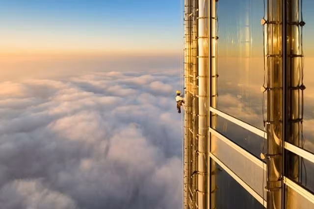 Một thợ lau kính đang làm việc tại tòa nhà cao nhất thế giới - Burj Khalifa ở Dubai.