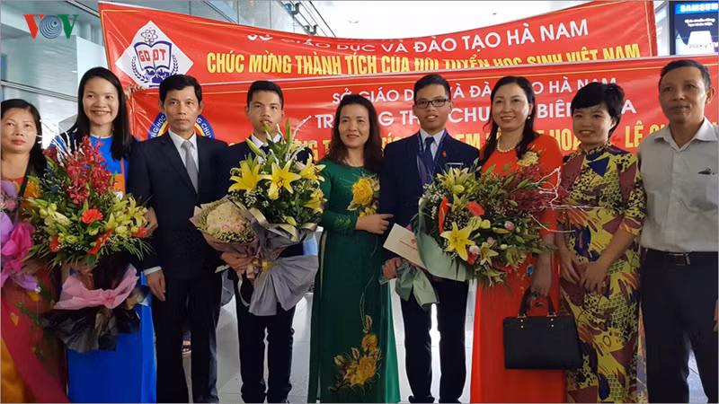 Gia đình và các thầy cô giáo chúc mừng 2 em từ Australia trở về nước sau kỳ thi.