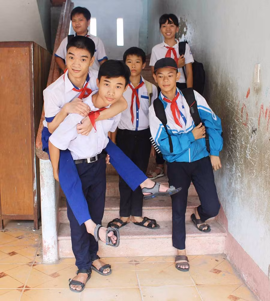  Em Nguyễn Viết Đức cõng bạn Vũ Phương Nam sau giờ tan trường. Ảnh: P.L