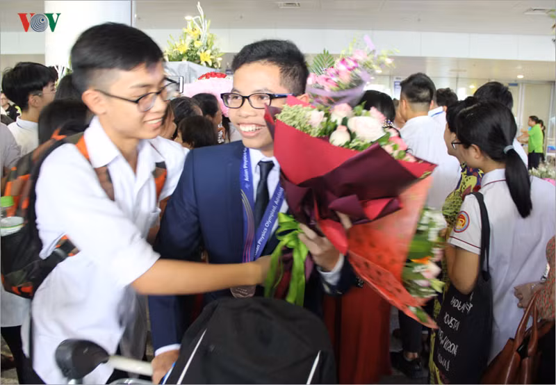 Em Lê Việt Hoàng, học sinh lớp 12, trường THPT chuyên Biên Hòa, tỉnh Hà Nam đoạt huy chương Đồng trở về trong sự chào đón thân tình của bạn bè.