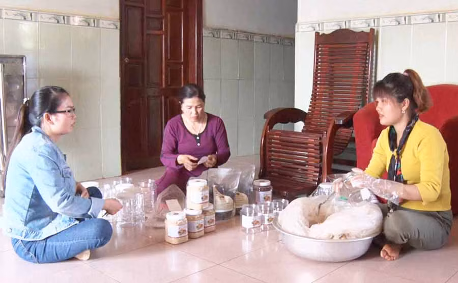  Chị Trương Thị Bé (bìa phải) đóng bột ngũ cốc giao cho khách. Ảnh: Huyền Trân
