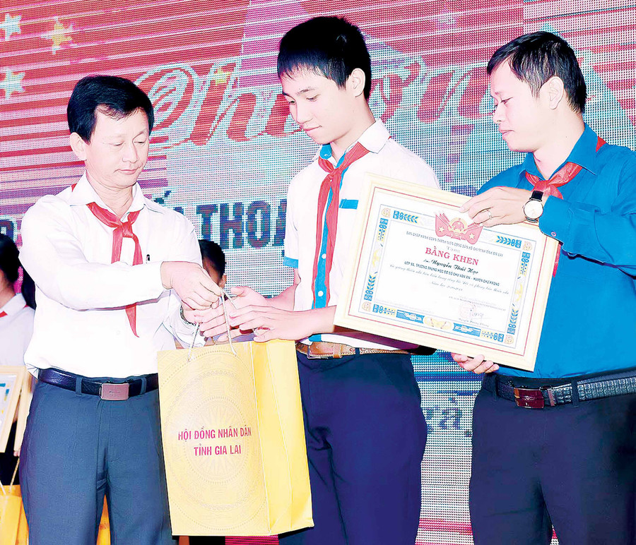  Đồng chí Dương Văn Trang (bìa trái)-Ủy viên Ban Chấp hành Trung ương Đảng, Bí thư Tỉnh ủy, Chủ tịch HĐND tỉnh trao quà của HĐND tỉnh cho thiếu nhi tiêu biểu có hành động đẹp, việc làm tốt. Ảnh: Đức Thụy