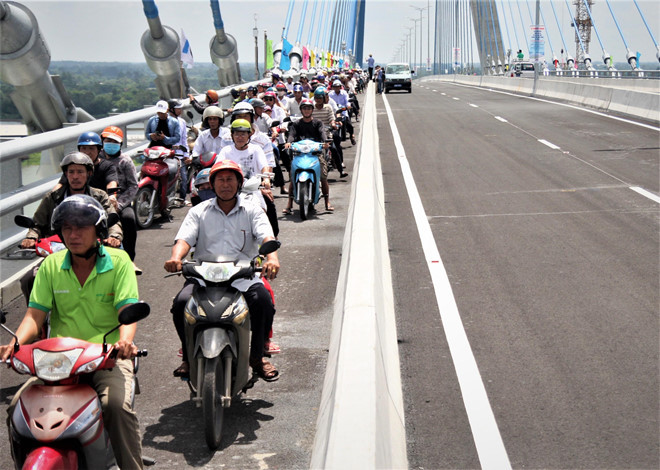 Người dân hào hứng đi lên cầu Vàm Cống sau nhiều năm phải lụy phà. Ảnh: T.K.