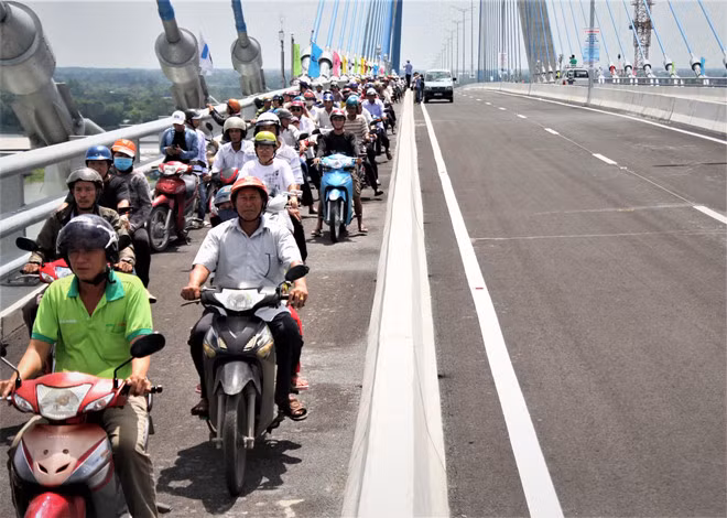 Người dân hào hứng đi lên cầu Vàm Cống sau nhiều năm phải lụy phà. Ảnh: T.K.