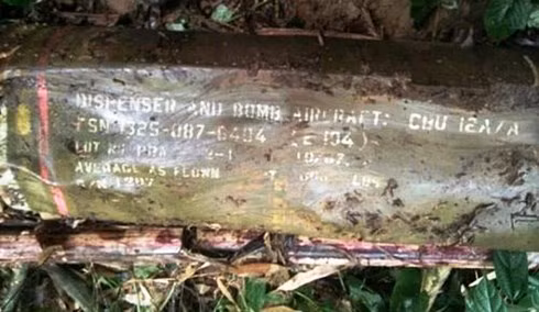  Quả bom dài gần 2m, trên vỏ bom có nhiều ký tự màu trắng.