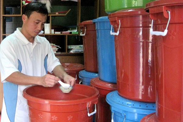 Anh Phạm Thế Chính bổ sung thức ăn và nước uống cho dế. Ảnh: Hồng Thi. Anh Phạm Thế Chính bổ sung thức ăn và nước uống cho dế. Ảnh: Hồng Thi.