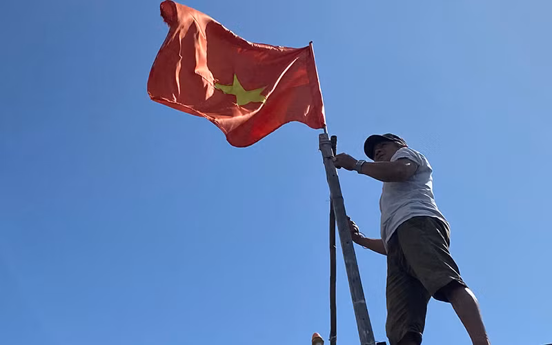  Ngư dân Lê Văn Chiến treo cờ Tổ quốc trên tàu cá.