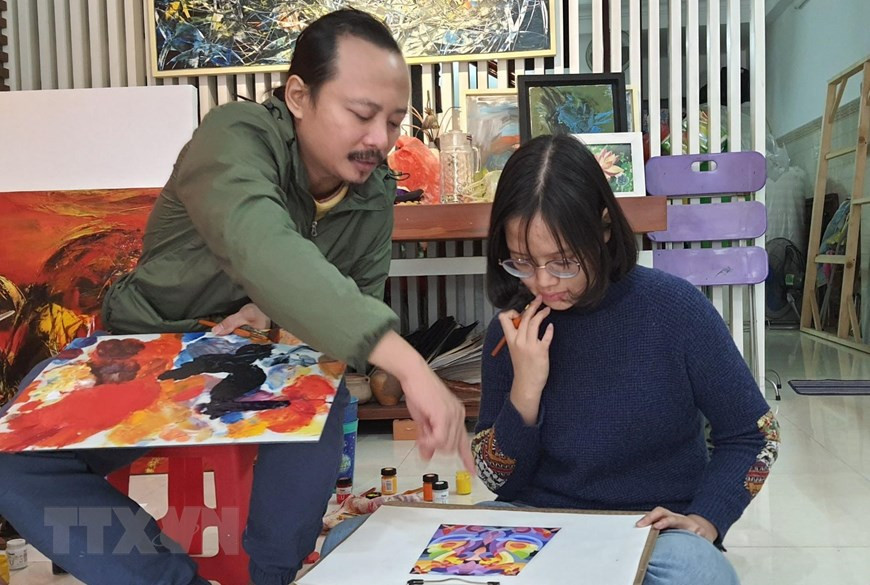  Họa sỹ Ngô Thanh Hùng dạy học sinh vẽ tại nhà. (Ảnh: Văn Dũng/TTXVN)