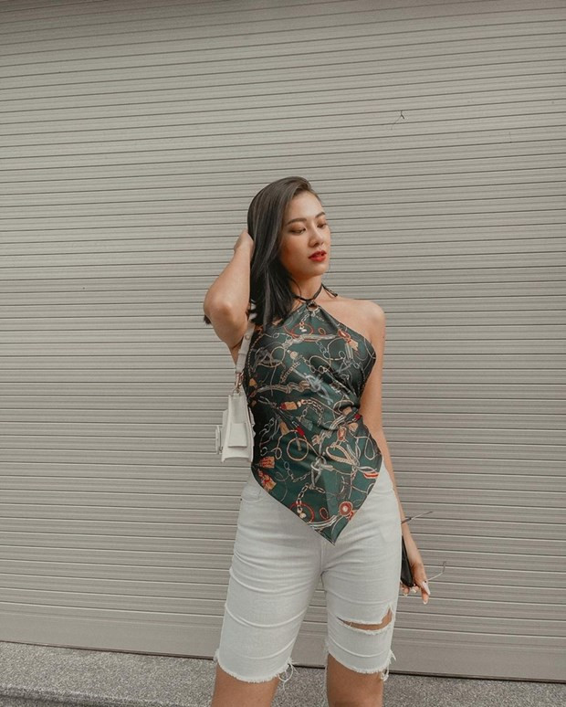  Kim Duyên lăngxê quần biker short với áo yếm hoạ tiết khăn lụa, tôn đường cong và bờ vai gợi cảm.