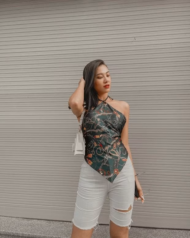  Kim Duyên lăngxê quần biker short với áo yếm hoạ tiết khăn lụa, tôn đường cong và bờ vai gợi cảm.