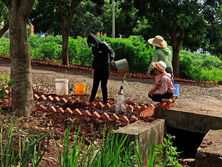 Phụ nữ làng Tao Kó trồng và chăm sóc con đường hoa của làng
