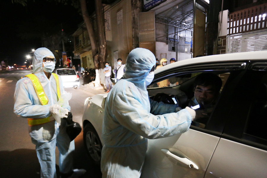 Lực lượng Cảnh sát Giao thông kiểm tra nồng độ cồn được trang bị quần áo bảo hộ y tế. Ảnh: Văn Ngọc