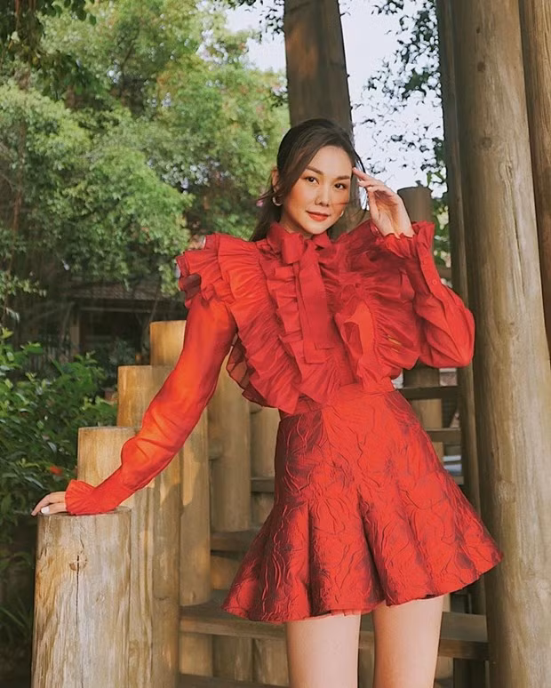 Sau áo dài khai niên, Thanh Hằng tiếp tục khoe sắc kiều diễm trong bộ trang phục rực đỏ. Sơmi xếp bèo và chân váy ngắn được phối ăn ý, tôn lên vẻ điệu đà, nữ tính của siêu mẫu.