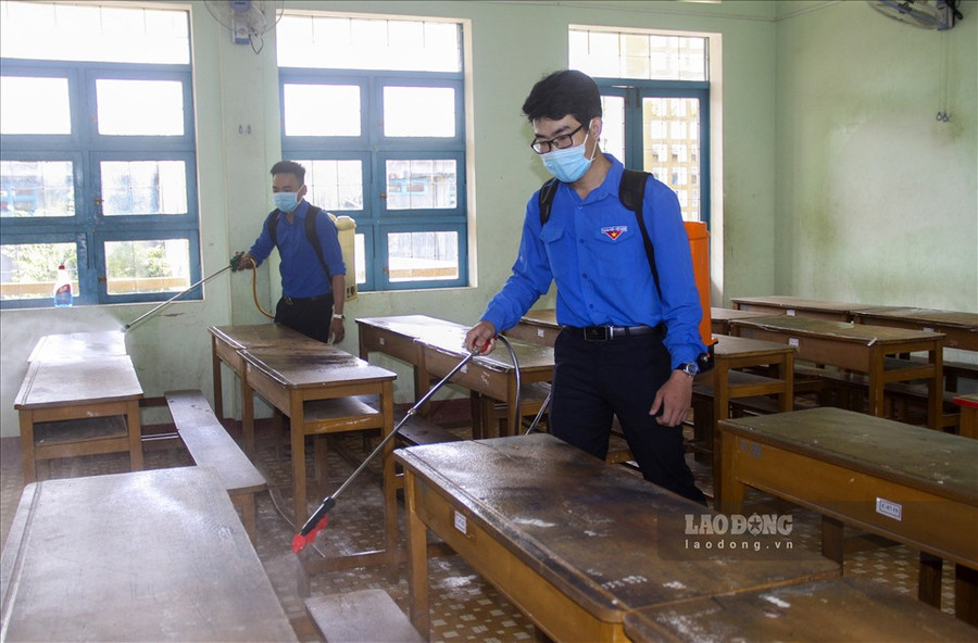  Đoàn viên thanh niên ở Bình Định phun thuốc khử trùng tại các phòng học. Ảnh: N.T