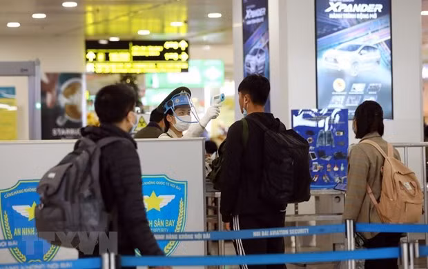 Nhân viên an ninh kiểm tra thân nhiệt của hành khách.