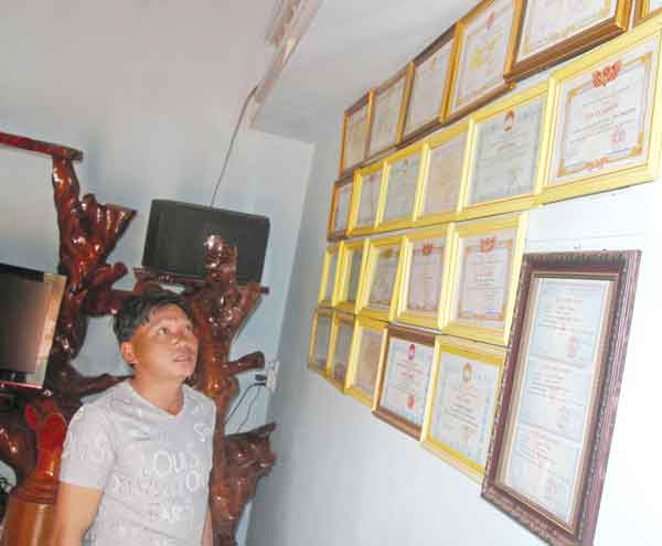 Anh Nguyễn Cao Nguyên tự hào với những giấy khen của cả gia đình qua các giải đấu. Ảnh: Văn Ngọc