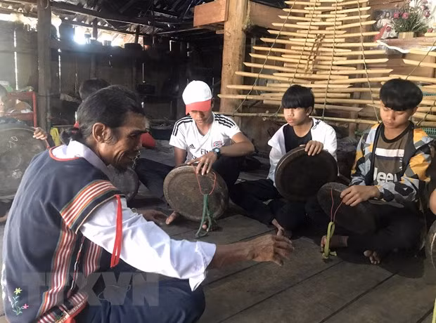 Ông A Thui dạy cồng chiêng cho các em nhỏ. (Ảnh: Khoa Chương/TTXVN)