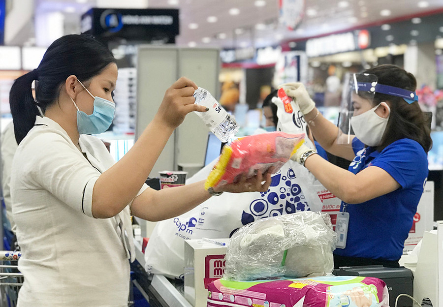 Nhân viên Siêu thị Co.op Mart Pleiku chọn sản phẩm khách hàng đặt mua qua điện thoại để tính tiền và giao hàng tận nơi. Ảnh: Vũ Thảo