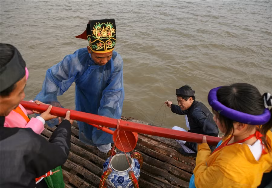 Nghi thức lấy nước ở giữa dòng sông Hồng. Ảnh tư liệu của Trịnh Thông Thiện.