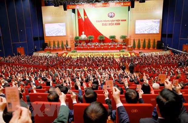 Các đại biểu biểu quyết, thông qua Nghị quyết Đại hội XIII Đảng Cộng sản Việt Nam. (Ảnh: TTXVN)