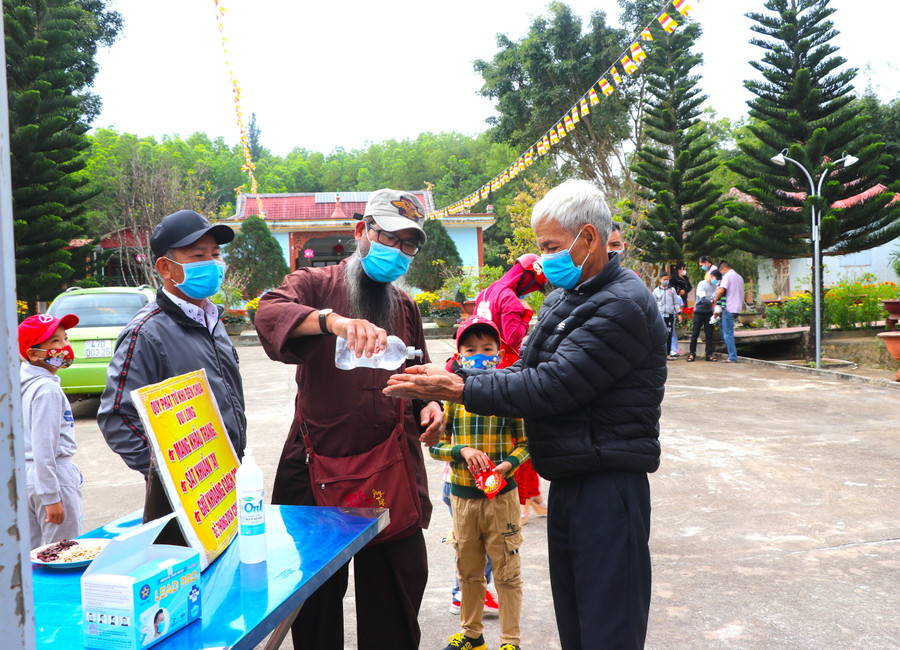 Người dân sát khuẩn trước khi vào lễ phật. Ảnh: Ngọc Minh