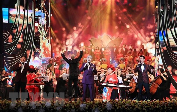 Nghệ sĩ nhân dân Quang Thọ, các nghệ sỹ và dàn nhạc mở màn chương trình Xuân Quê hương năm 2021 với hai ca khúc 'Hồ Chí Minh đẹp nhất tên Người' và 'Đường chúng ta đi.' (Ảnh: Lâm Khánh/TTXVN)