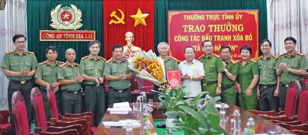 Đồng chí Châu Ngọc Tuấn-Phó Bí thư Thường trực Tỉnh ủy, Chủ tịch HĐND tỉnh trao phần thưởng cho Công an tỉnh về thành tích xuất sắc trong việc truy bắt 3 đối tượng tà đạo “Hà Mòn” cuối cùng. Ảnh: Thúy Trinh