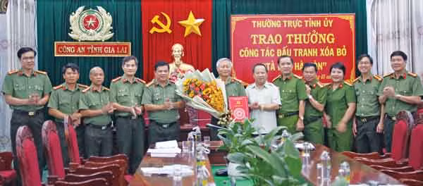 Đồng chí Châu Ngọc Tuấn-Phó Bí thư Thường trực Tỉnh ủy, Chủ tịch HĐND tỉnh trao phần thưởng cho Công an tỉnh về thành tích xuất sắc trong việc truy bắt 3 đối tượng tà đạo “Hà Mòn” cuối cùng. Ảnh: Thúy Trinh