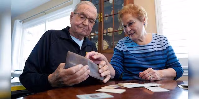 Ông Grisham và vợ xem chiếc ví bị thất lạc từ năm 1968. Ảnh: AP