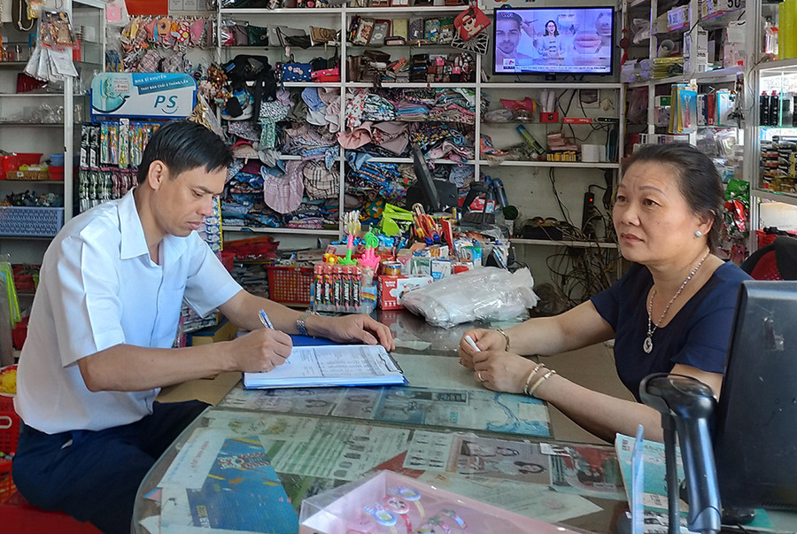 Cán bộ Chi cục Thuế huyện Chư P rông đang trao đổi nắm bắt tình hình với hộ kinh doanh. Ảnh: Sơn Ca