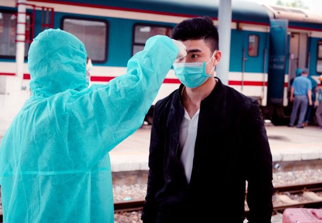 Nhân viên y tế túc trực tại ga Quảng Ngãi để kiểm tra thân nhiệt khách xuống ga sáng 4.2.