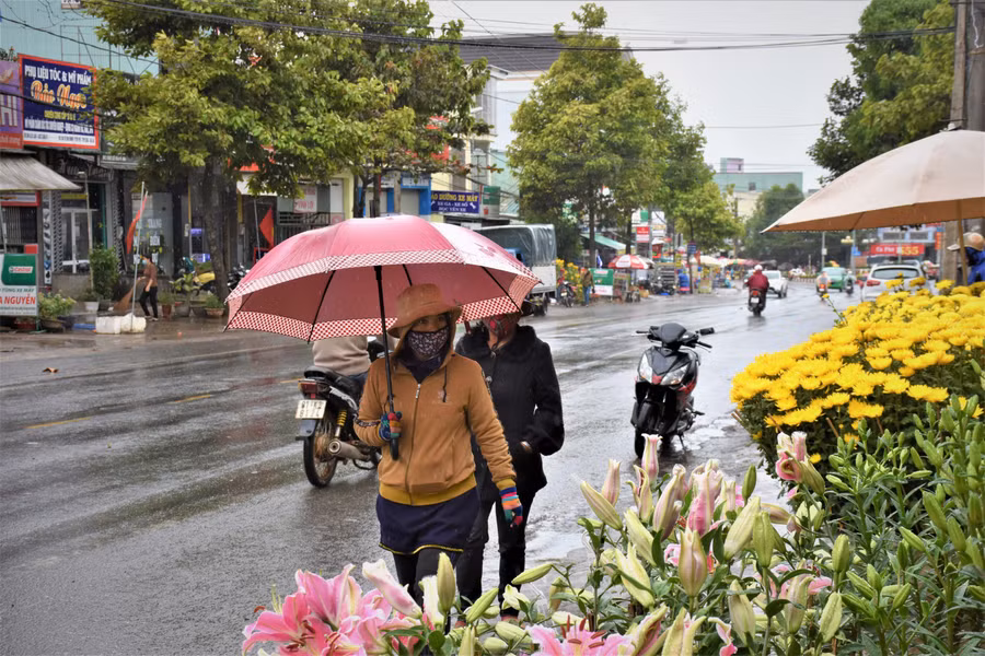 Nhiều người dân ở TP. Pleiku đội mưa đi chợ mua sắm trong ngày 29 Tết. Ảnh: Trần Dung 2- Nhiều người dân ở TP. Pleiku vẫn đội mưa đi chợ mua sắm trong ngày 29 Tết. Ảnh: Trần Dung.