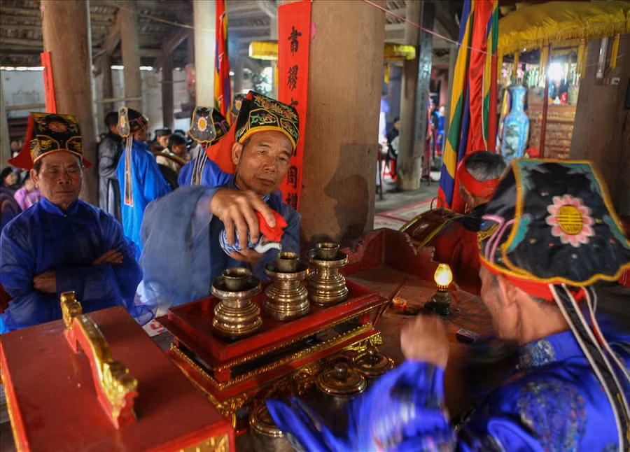 Nghi thức rót nước thiêng để dâng lên ban thờ. Ảnh tư liệu của Trịnh Thông Thiện.