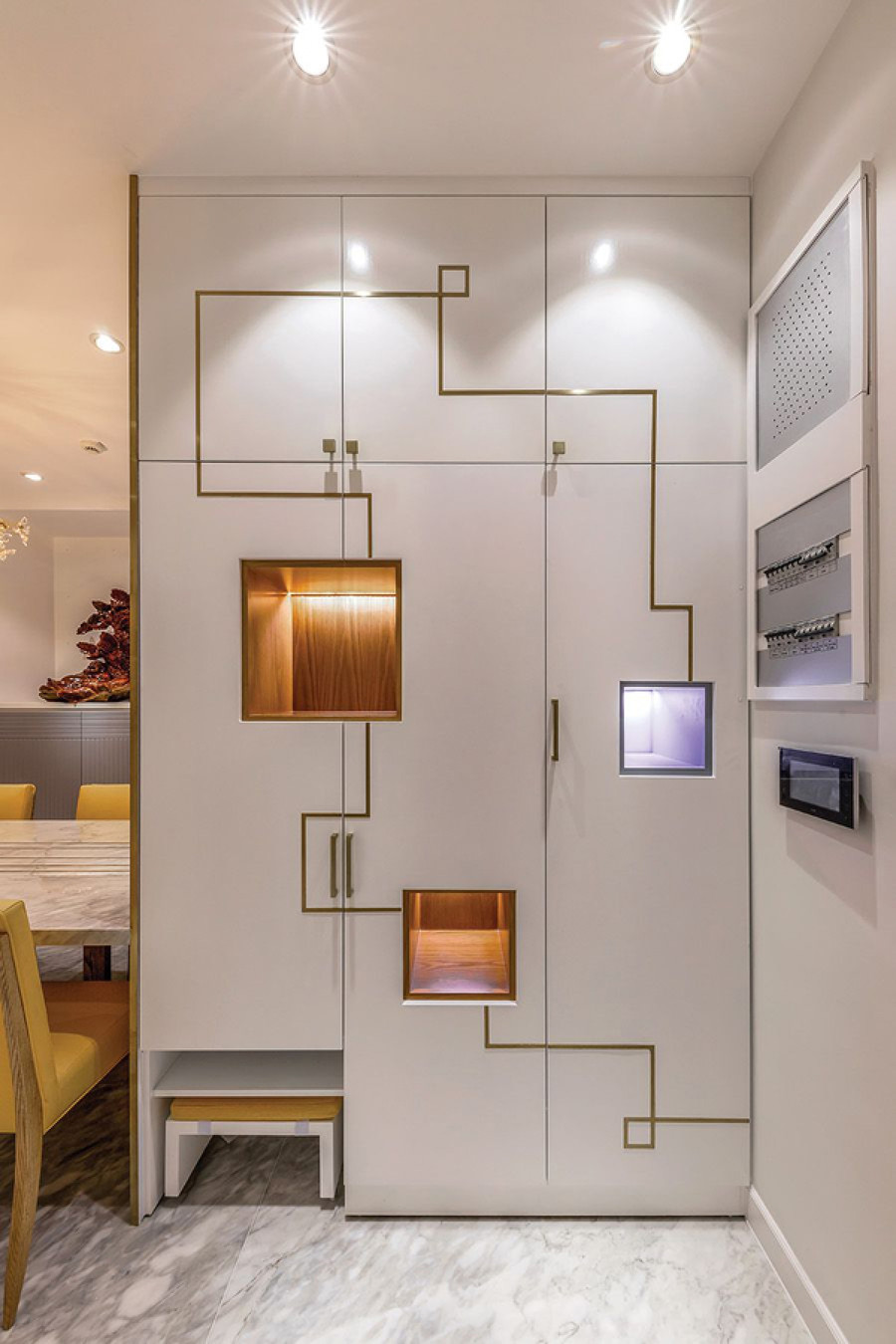 Chiếc tủ ở khu vực sảnh, kế bên bàn ăn được décor bề mặt cùng hệ thống chiếu sáng đầy cuốn hút.