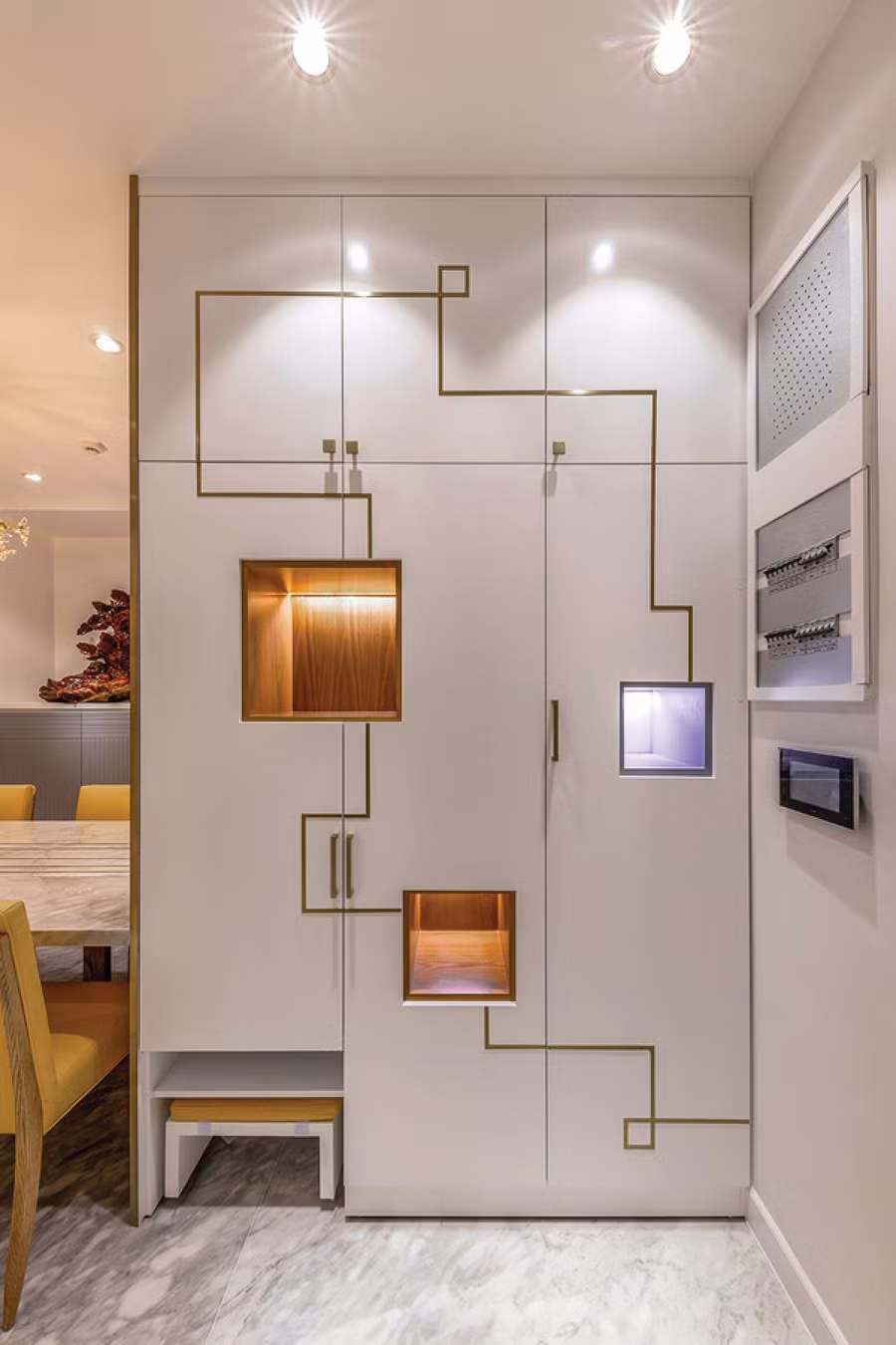 Chiếc tủ ở khu vực sảnh, kế bên bàn ăn được décor bề mặt cùng hệ thống chiếu sáng đầy cuốn hút.