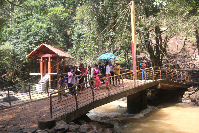 Du khách chụp ảnh lưu niệm tại cầu ở khu vực dưới thác