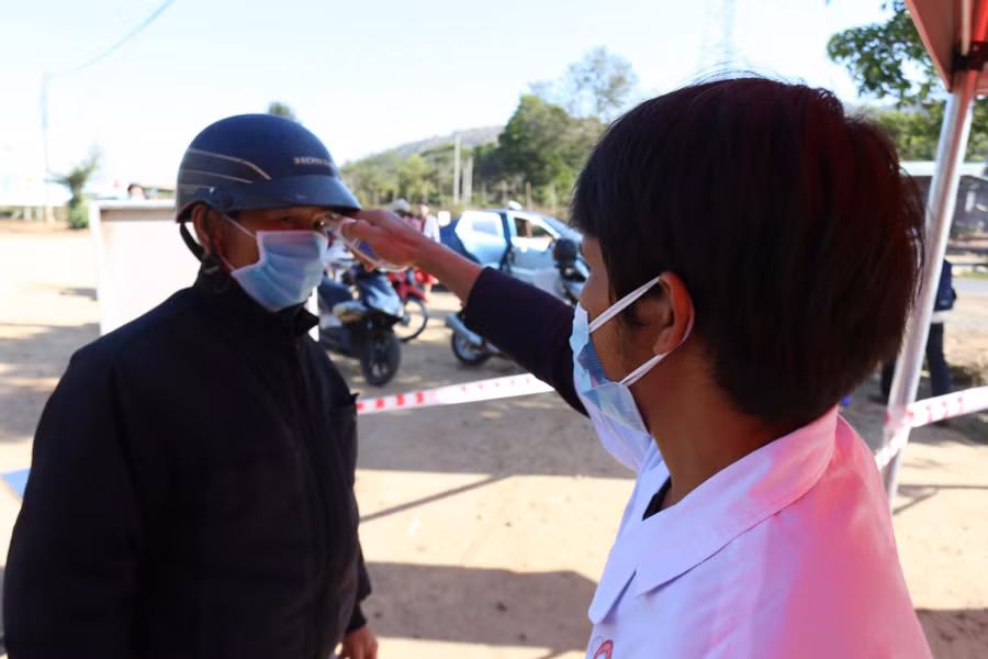 Người dân buộc phải sát khuẩn tay và đo thân nhiệt