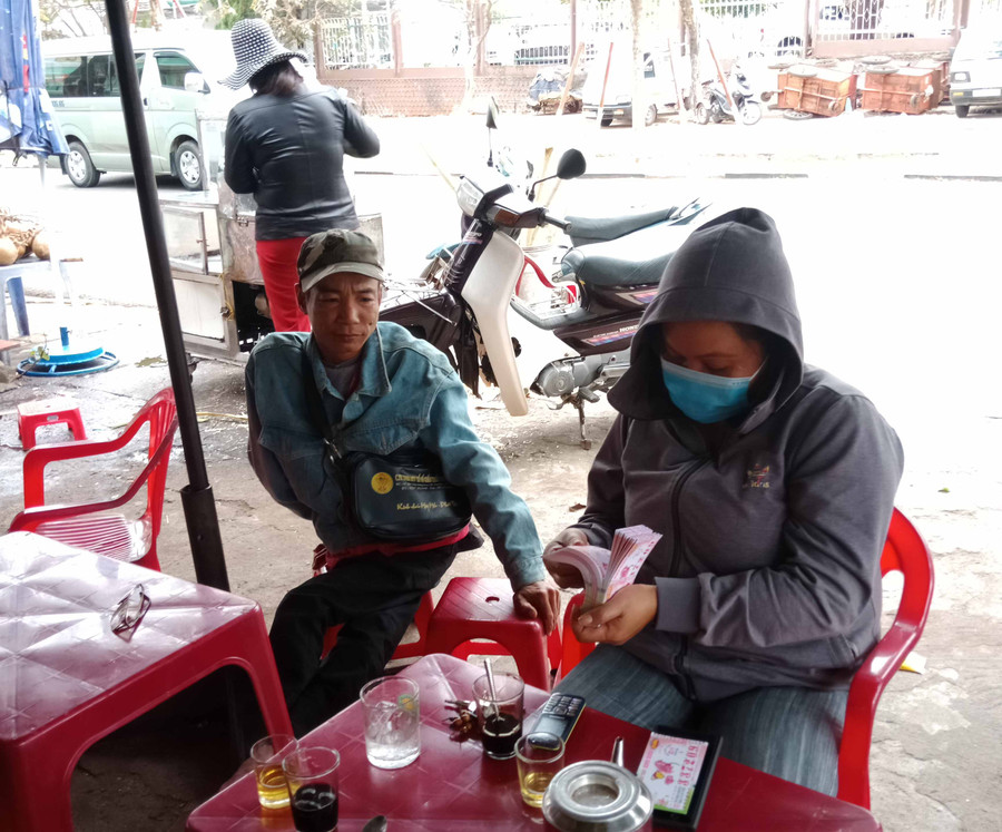 Anh Trần Văn Phương mời khách mua vé số. Ảnh: Nguyễn Đình