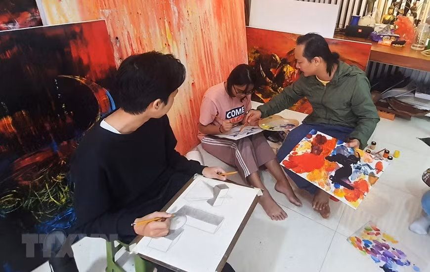 Họa sỹ Ngô Thanh Hùng dạy học sinh vẽ tại nhà. (Ảnh: Văn Dũng/TTXVN)